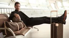 Lionel Messi posando con los pies sobre una maleta Louis Vuitton