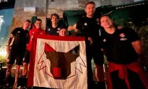 Jugadores del Atlas afuera del hotel con una bandera que llevaron los seguidores