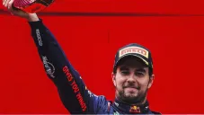 Checo en el podio levantando trofeo