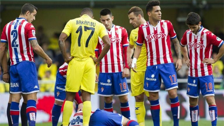 Jugadores del Gijón observan a uno de sus compañeros en el suelo