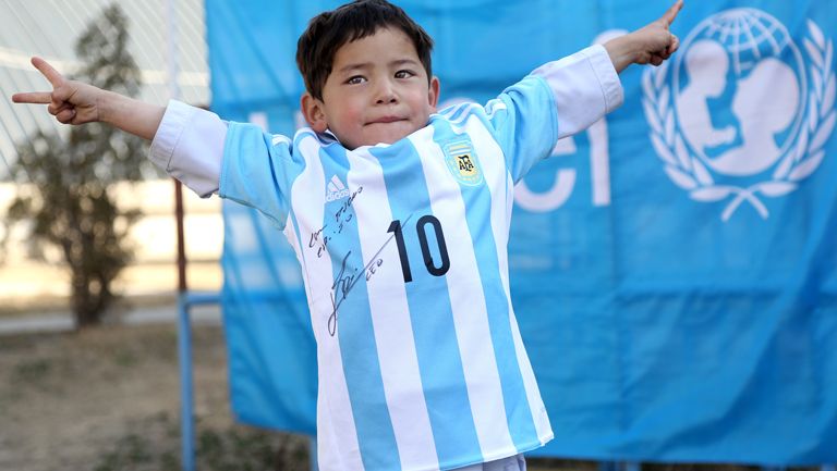 Niño afgano posa con su playera firmada por Messi