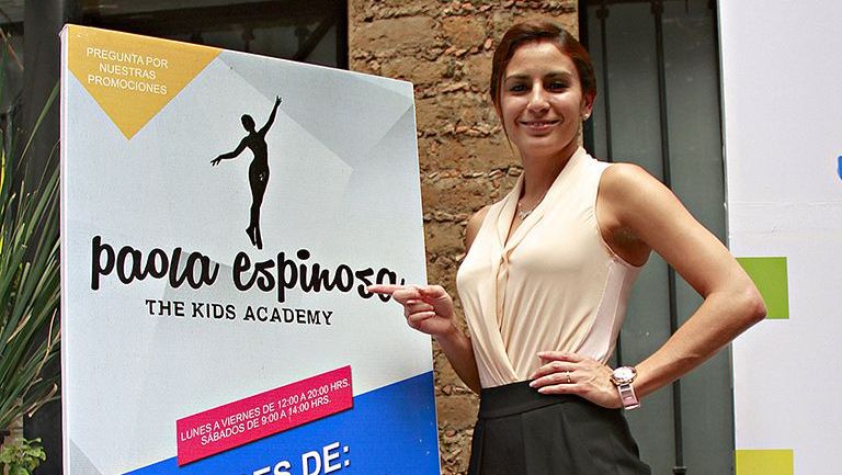 Paola posa junto a un cartel de su academia