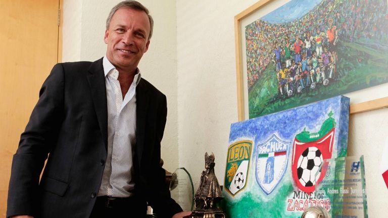 Fassi posa junto a un trofeo y los escudos de los equipos de Grupo Pachuca