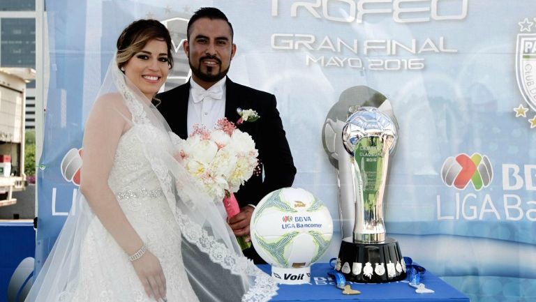 Los recién casados posando con el trofeo de la Liga MX