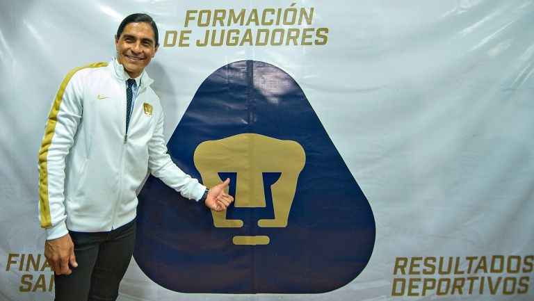 Paco Palencia posa para las cámaras junto al escudo de Pumas