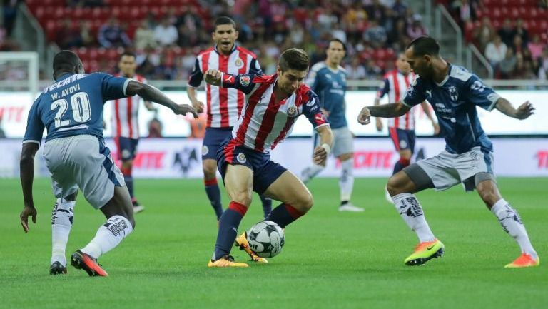 Isaac Brizuela intenta pasar entre dos jugadores rayados