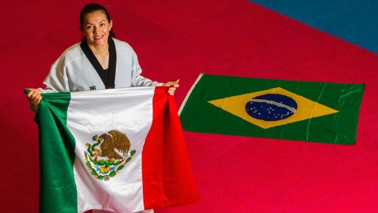 María del Rosario Espinoza sostiene la bandera mexicana con una de Brasil al fondo