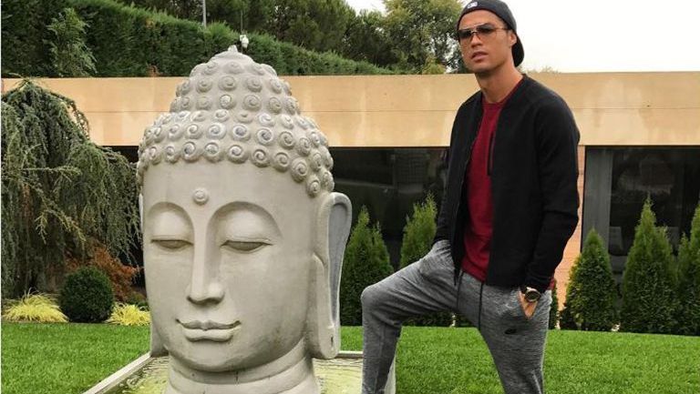 Cristiano Ronaldo posa junto a estatua de Buda