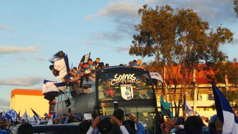 Jugadores de Querétaro celebran el título de Copa MX paseando sobre un camión