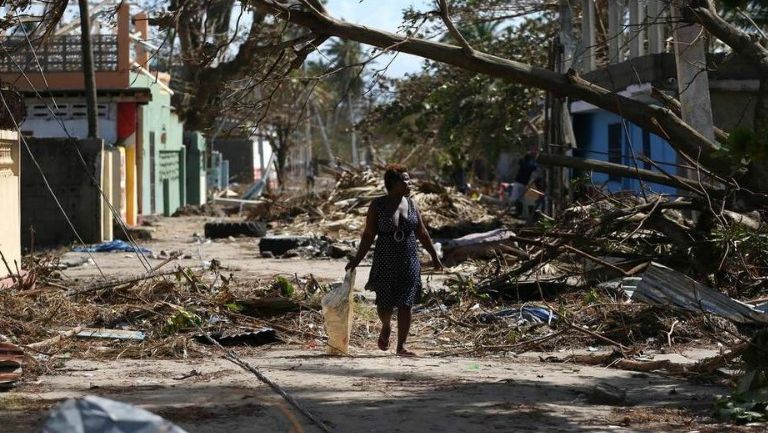 Una mujer camina por una zona de desastre tras el paso de Matthew