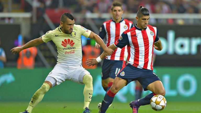 Miguel Samudio y Alan Pulido pelean un balón