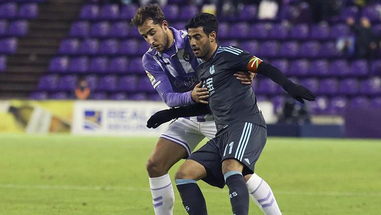Carlos Vela protege el balón ante la marca de un rival