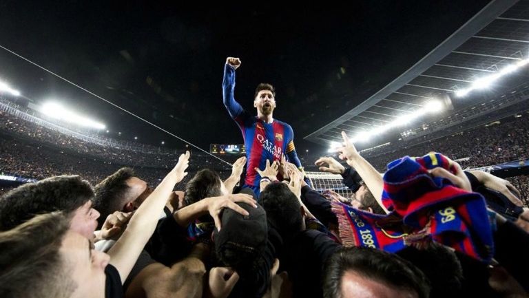 Lionel Messi es cargado por los aficionados tras el triunfo del Barcelona en Champions League