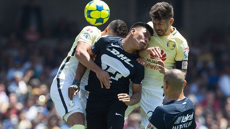 Jugadores de Pumas y América lucha por el balón 