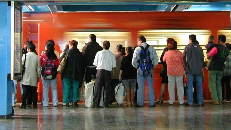 Un grupo de personas esperan la llegada del metro