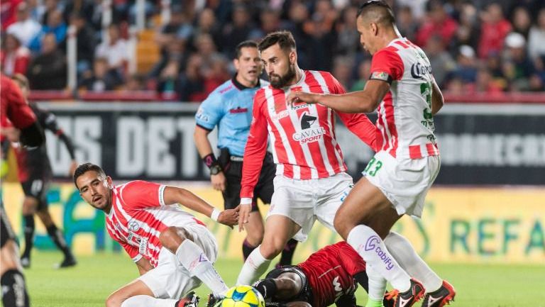 Jugadores de Necaxa disputan un balón en el juego contra Atlas