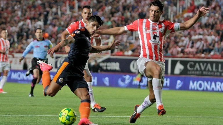 Alan Pulido intenta realizar un recorte durante el partido con Necaxa