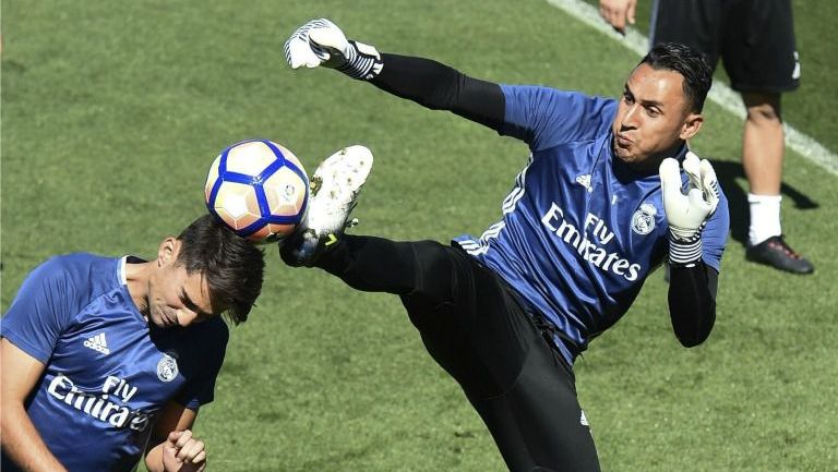 Keylor Navas golpea el balón con su pierna muy cerca de la cabeza de Enzo Zidane 