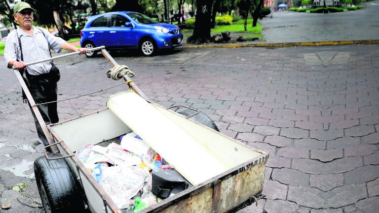 Un hombre arrastra una carreta para recolectar basura