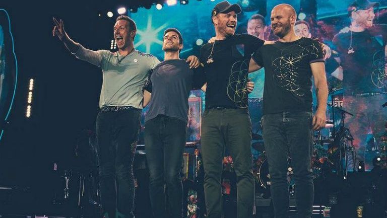 Miembros de Coldplay sonríen tras un concierto