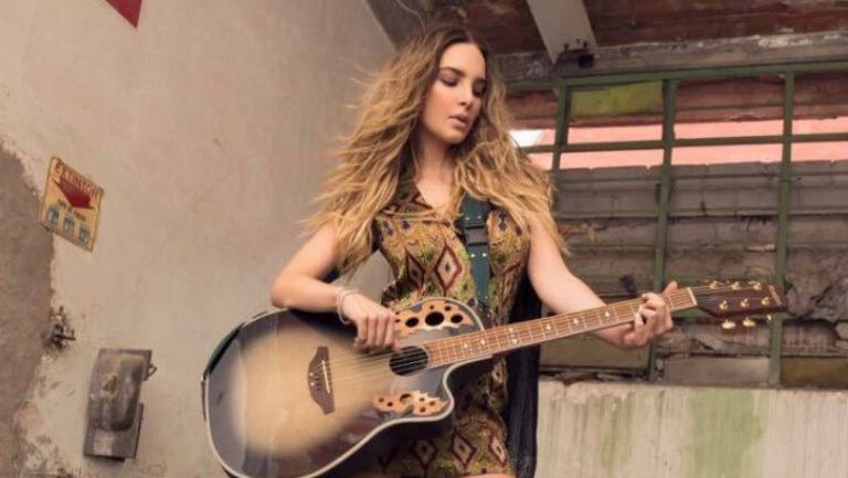 Belinda tocando una guitarra durante un sesión fotográfica