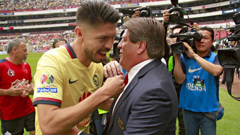 Oribe Peralta y Miguel Herrera se dan un abrazo durante un partido en el Azteca