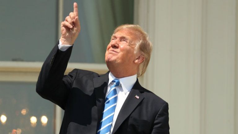 Trump apunta al cielo durante el eclipse solar