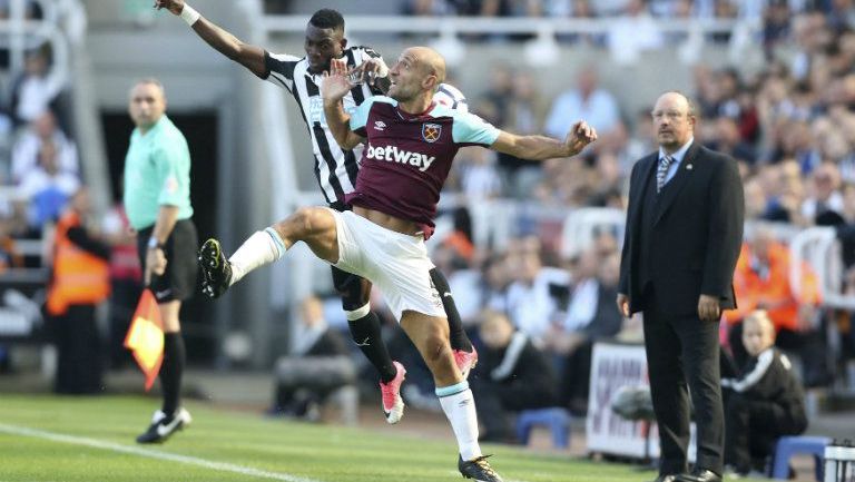 Christian Atsu y Pablo Zabaleta del West Ham pelean un balón en el aire