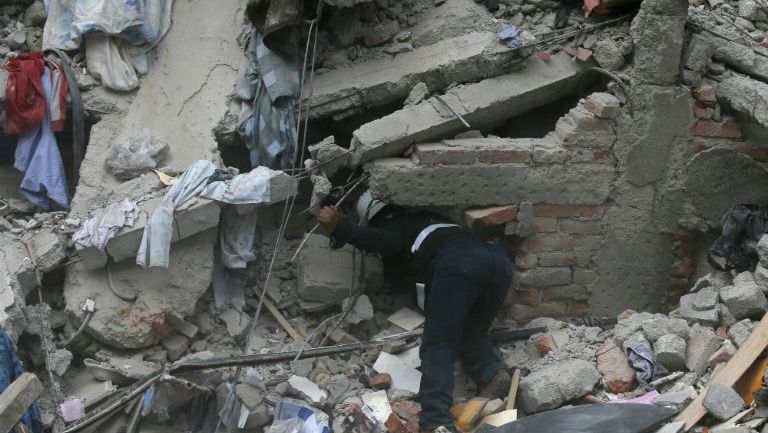 Un rescatista intenta ubicar a personas atrapadas por el terremoto