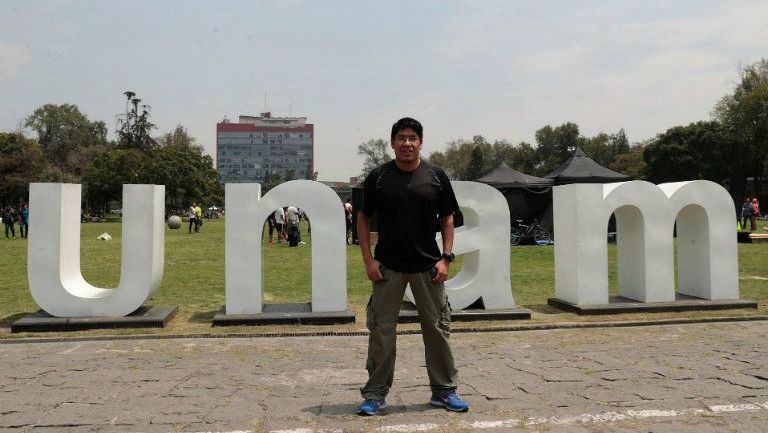 Marco A. Zaragoza posa frente a las iniciales de su universidad