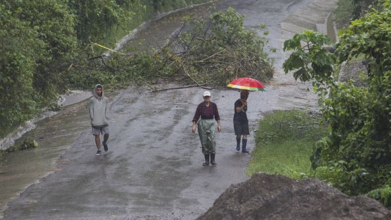 Gente camina por una carretera deslavada de Costa Rica