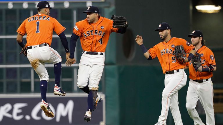 Jugadores de los Astros festejan tras anotar