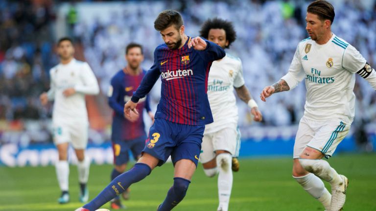 Piqué remata un balón en el Clásico Español 