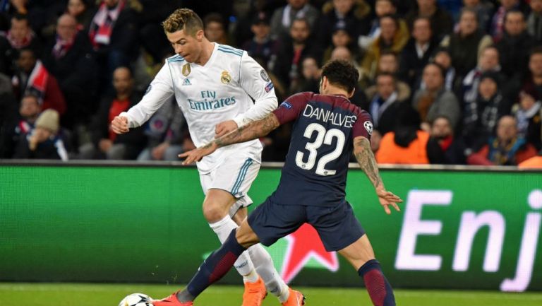 Dani Alves intenta quitarle el balón a Cristiano Ronaldo 