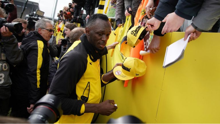Bolt firma autógrafos en el entrenamiento del BVB 