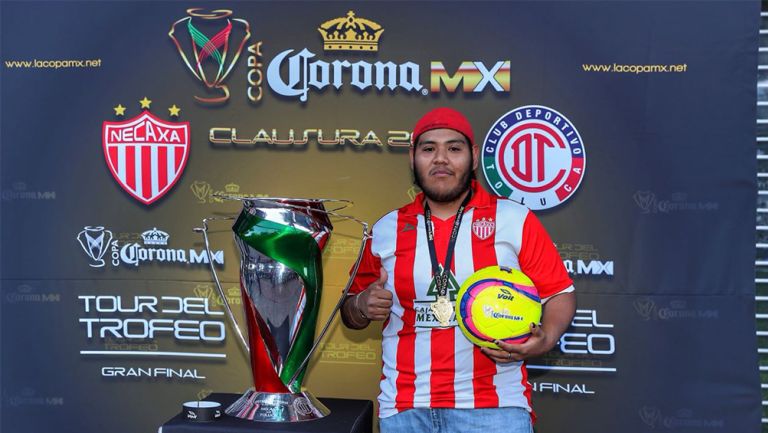 Aficionado de los Rayos posa junto al trofeo de la Copa MX