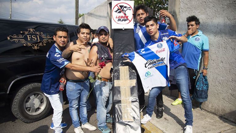 Aficionados de Puebla posan con un ataúd para despedir a Lobos