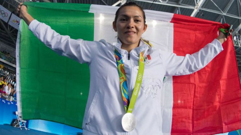 María Espinoza sostiene con alegría la bandera de México