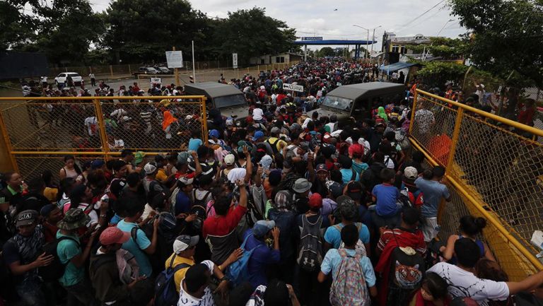 Migrantes cruzan la cerca que divide a México y Guatemala