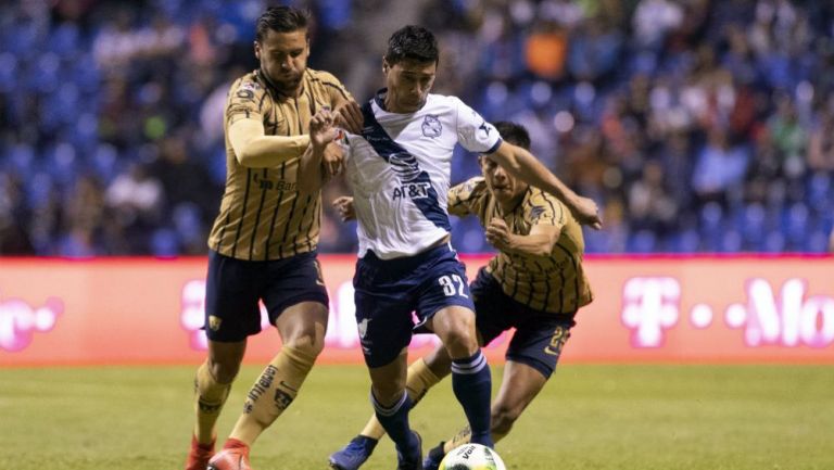 Alustiza conduce el balón ante la marca de dos jugadores de Pumas