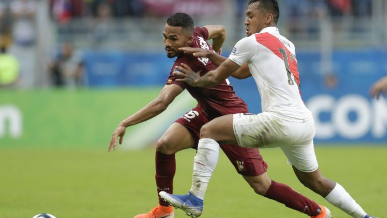 Jugadores de Venezuela y Perú en disputa por el balón 