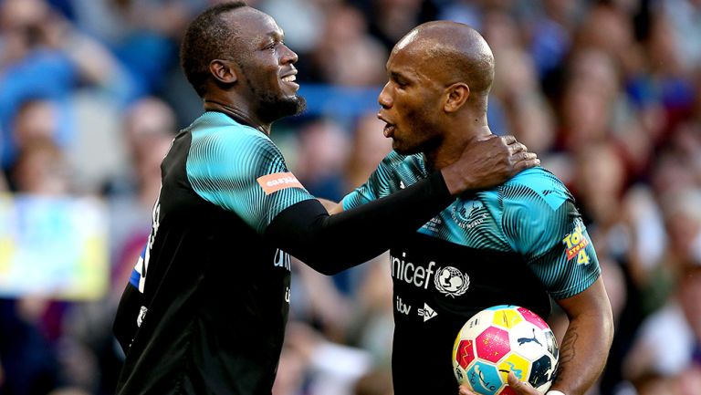 Bolt y Drogba celebran uno de los tantos durante el duelo benéfico