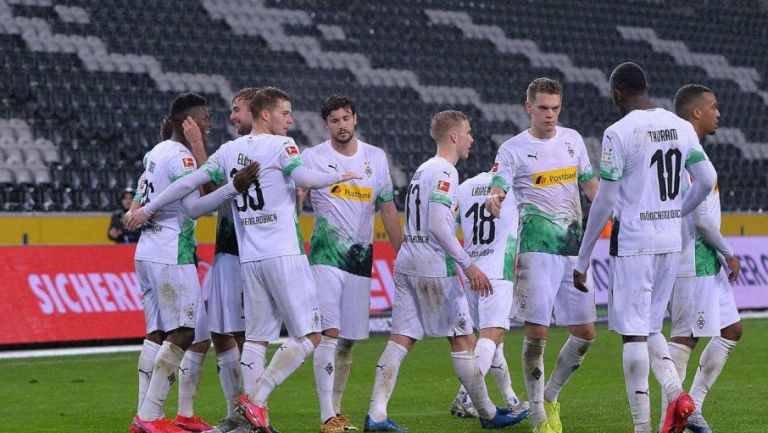 Jugadores del Gladbach festejan un gol en un inmueble sin público