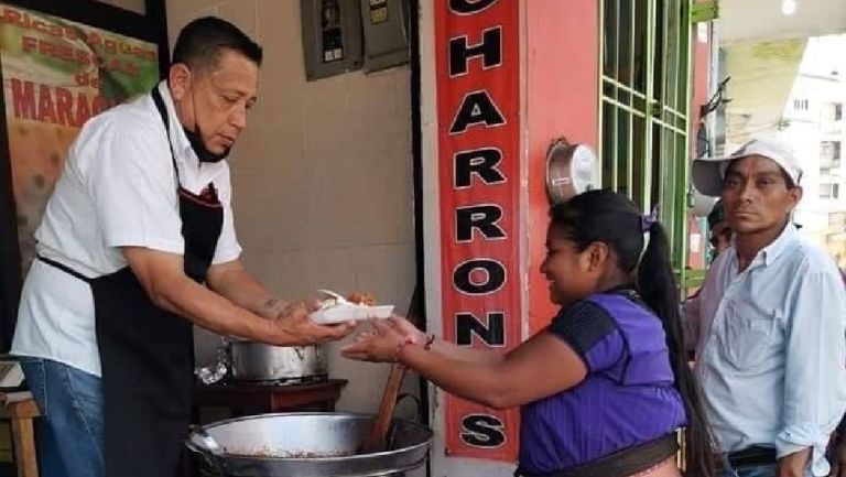 Taquero entregando comida a una mujer