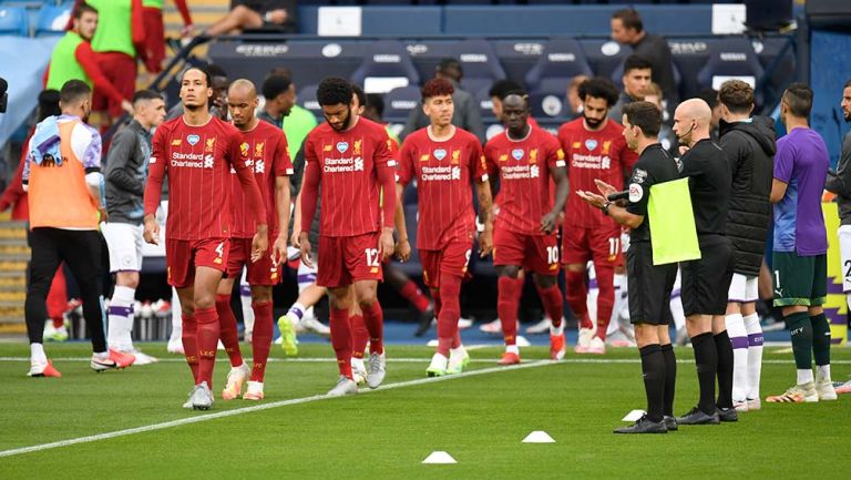 Jugadores del Liverpool ingresan al campo entre los futbolistas del City