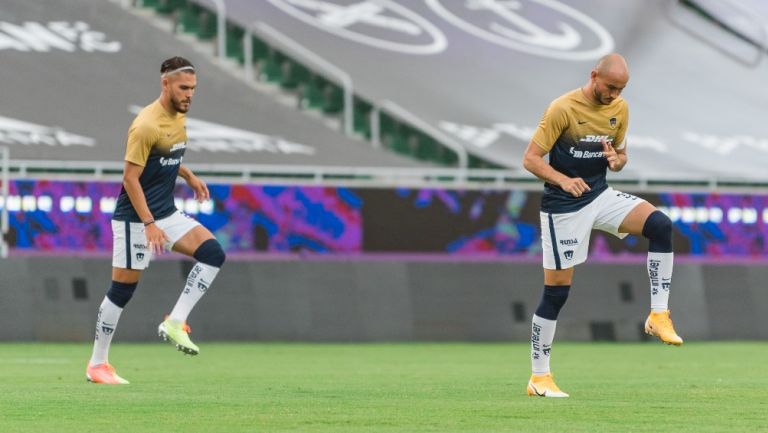 Nicolás Freire y Carlos González en calentamiento con Pumas en el Apertura 2020