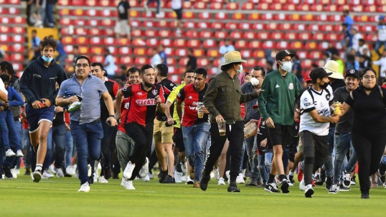 Aficionados buscando refugio en la cancha de la Corregidora